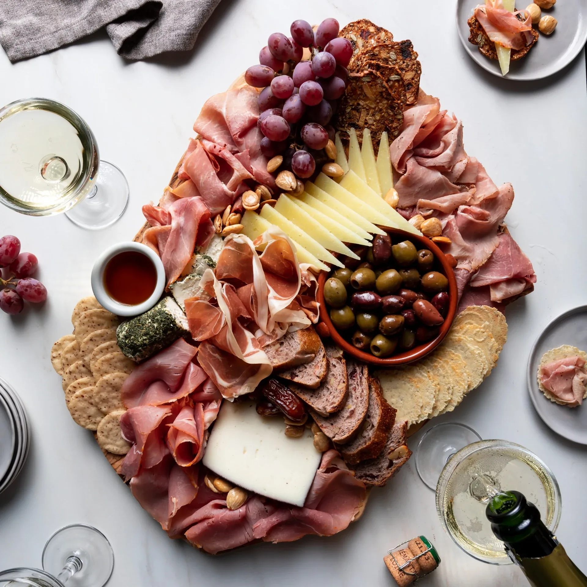 La Quercia jambon board with cured meats, cheeses, grapes, olives and crackers